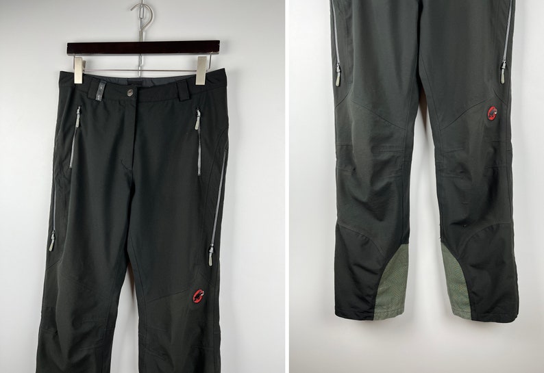 May include: Black hiking pants with zippered pockets and a red logo on the right leg.