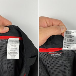 May include: Black and red label with the text "schoeller&reg; Switzerland" and "WB - formula" on a black fabric background. The label also includes care instructions and the text "MAMMUT&reg;".