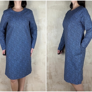 以下が含まれることがあります： 青と白の模様の入った、長袖で丸首のワンピース。ワンピースは体にフィットしたシルエットで、膝丈です。