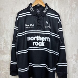 May include: Black long-sleeve rugby shirt with white horizontal stripes and the text "northern rock" in large white letters. The shirt also features the "Newcastle Falcons" logo and "KooGa MADE FOR RUGBY" text.