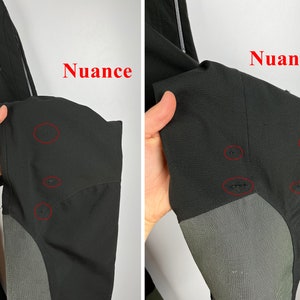 May include: Black pants with a gray panel on the knee. The pants have several small holes in the fabric. The word "Nuance" is written in red on the image.