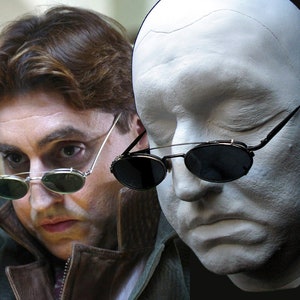 May include: A close-up of a man wearing round, green sunglasses. The sunglasses are flipped up on his head. The man is wearing a brown leather jacket. A white plaster cast of a face with the same sunglasses is shown next to the man.