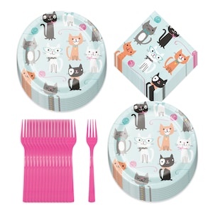 May include: A set of blue and white paper plates with a cat theme. The plates feature various cats with yarn balls and glasses. The set also includes pink plastic forks and a stack of blue and white napkins with a cat theme.