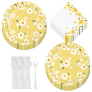 May include: A set of yellow daisy-themed party supplies. Includes stacks of round plates, napkins, and a bundle of white plastic forks. The plates and napkins feature a repeating pattern of white daisies with yellow centers.