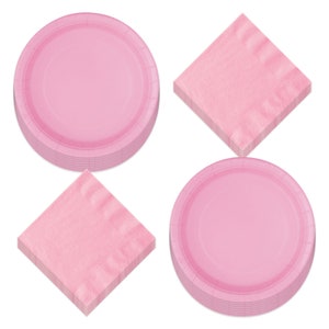 May include: Pink paper plates and napkins for a party or event. The plates are stacked and the napkins are folded.