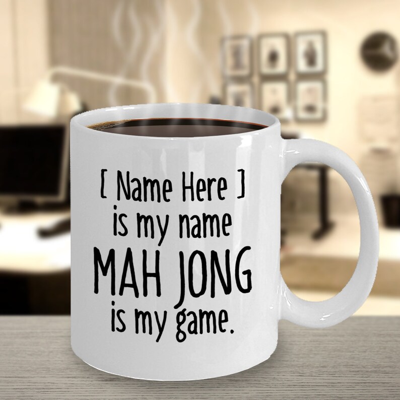 May include: White ceramic coffee mug with black text that reads "[Name Here] is my name MAH JONG is my game."