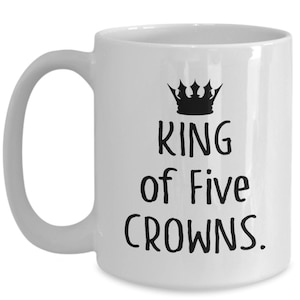 May include: White ceramic coffee mug with a black crown and the text "King of Five Crowns."