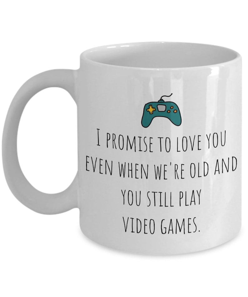 May include: White ceramic coffee mug with a black and green video game controller graphic and the text "I promise to love you even when we're old and you still play video games."