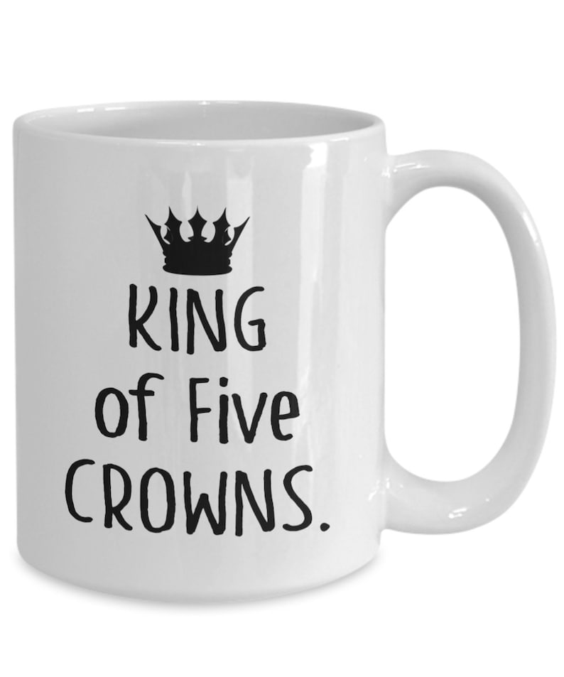 May include: White ceramic mug with a black crown and the text "KING of Five CROWNS."