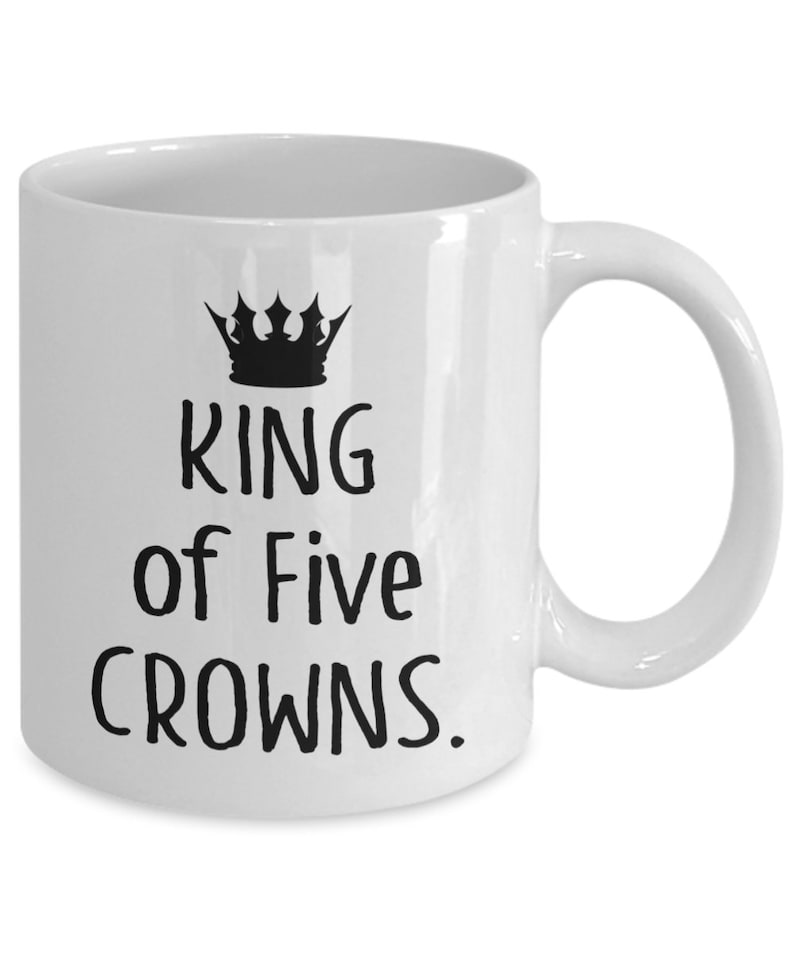 May include: White ceramic coffee mug with a black crown and the text "KING of Five CROWNS."