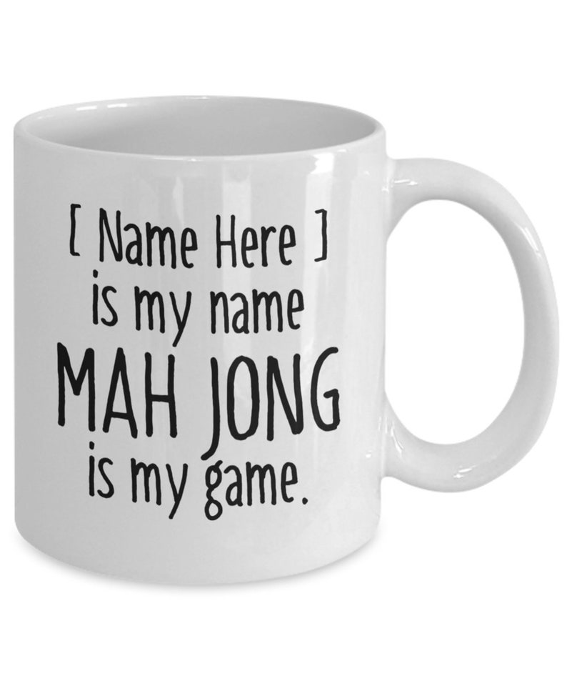 May include: White ceramic coffee mug with black text that reads "[ Name Here ] is my name MAH JONG is my game."