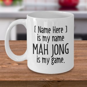 May include: White ceramic coffee mug with black text that reads "[Name Here] is my name MAH JONG is my game."