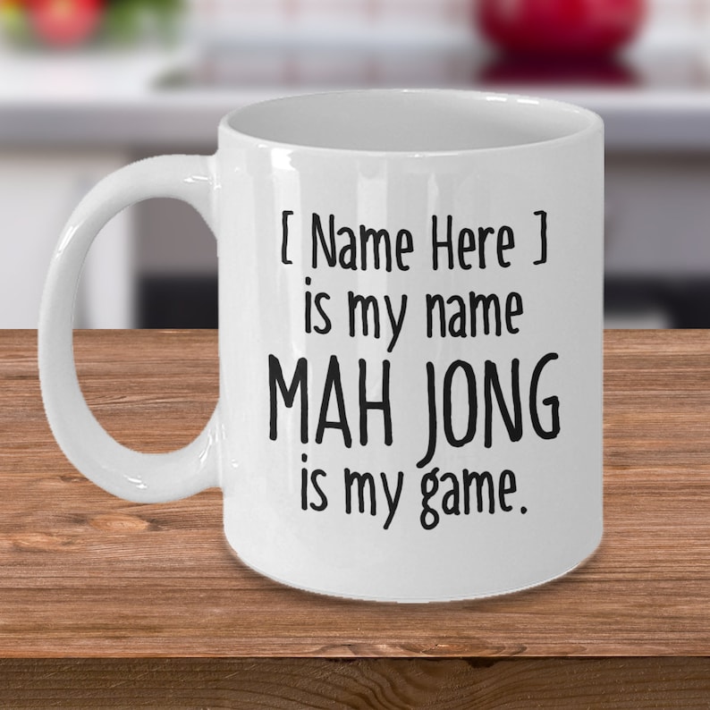 May include: White ceramic coffee mug with black text that reads "[Name Here] is my name MAH JONG is my game."
