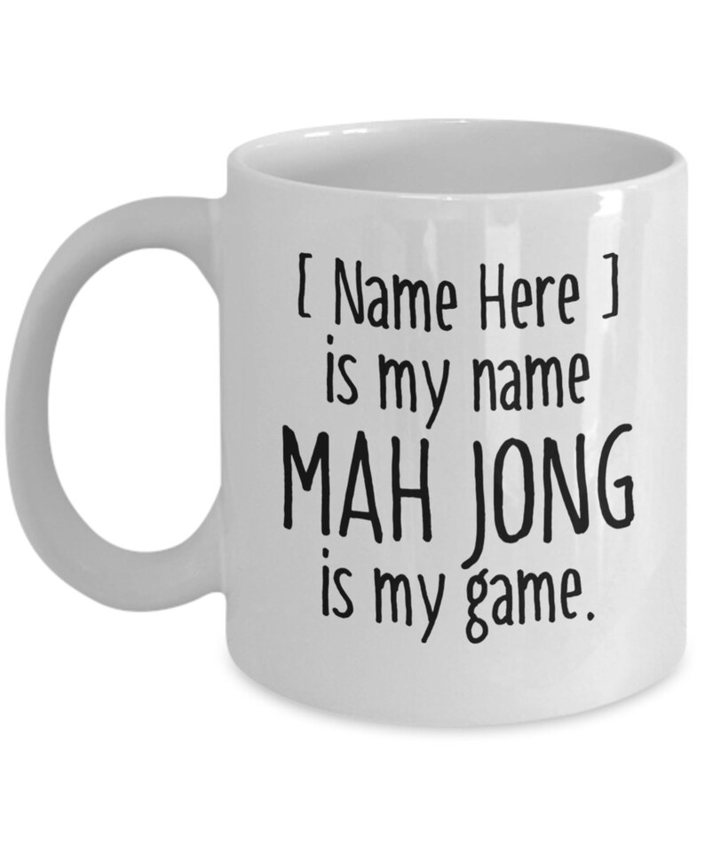 May include: White ceramic coffee mug with black text that reads "[ Name Here ] is my name MAH JONG is my game."