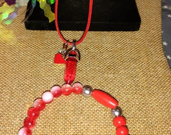 Conjunto: collar con punta de cristal y pulsera con dije.