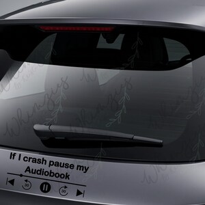 May include: Black car decal with the text "If I crash pause my Audiobook" and a media player control graphic. The decal is applied to the rear window of a vehicle.