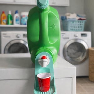 May include: A green detergent bottle with a built-in dispenser and a red cup. The dispenser is light blue and holds a small red cup. The bottle has a handle and a light blue top. The background shows a laundry room.