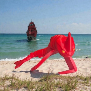 Könnte beinhalten: Eine leuchtend rote Skulptur einer gehörnten Kreatur mit gelben Augen, die an einem Sandstrand mit einem rot besegelten Schiff im Hintergrund posiert. Die Skulptur hat einen langen, segmentierten Körper, vor blauem Himmel und Meer.