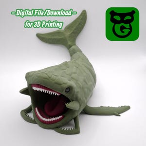 May include: A green 3D-printed model of a sea monster with an open mouth, showing white teeth and a red tongue. The model has a textured surface and a tail fin. Text on the image reads: "-Digital File/Download- for 3D Printing."