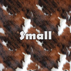 May include: A close-up of a brown and white cowhide pattern with the word "small" printed in white letters.