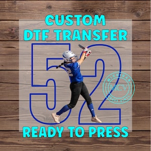 May include: Custom DTF transfer with the number 52 in blue outlined in white. A girl wearing a blue jersey with the number 2 is swinging a bat. The text "READY TO PRESS" is in blue outlined in white.