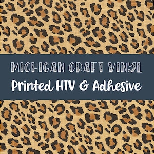 May include: A digital image featuring a leopard print pattern in shades of brown and tan. The design is bisected by a dark blue banner with the text "MICHIGAN CRAFT VINYL" above "Printed HTV & Adhesive" in white.