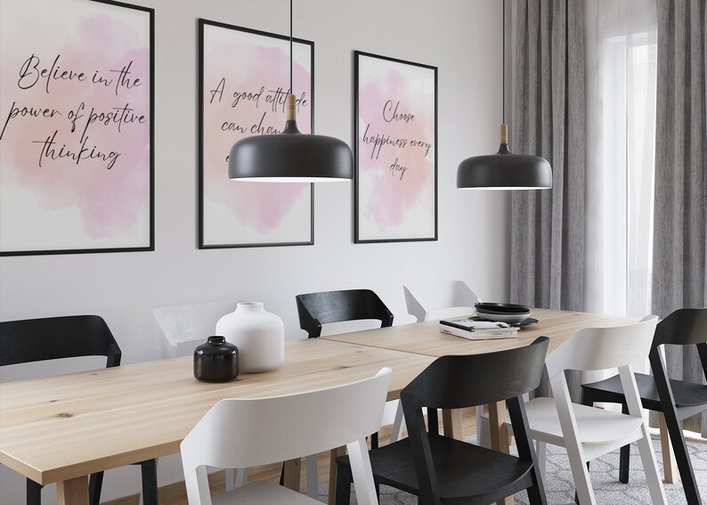 Peut inclure: Une salle &agrave; manger avec une table en bois et six chaises. Trois des chaises sont noires et trois sont blanches. Il y a trois impressions encadr&eacute;es sur le mur avec des citations inspirantes. Deux lampes suspendues noires pendent du plafond.
