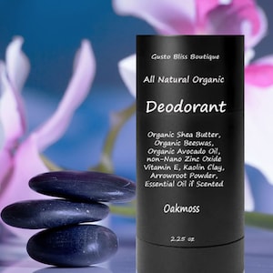May include: Black deodorant stick with white text that reads "Gusto Bliss Boutique All Natural Organic Deodorant" and lists ingredients including shea butter, beeswax, avocado oil, zinc oxide, vitamin E, kaolin clay, arrowroot powder, and essential oil. The text also reads "Oakmoss" and "2.25 oz".