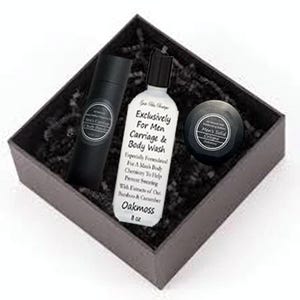 May include: A gray gift box with black shredded paper inside. The box contains a white bottle of body wash labeled "Exclusively For Men Carriage & Body Wash", a black tube of body lotion, and a black round container of solid cologne labeled "Men's Solid Cologne".