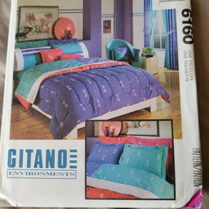 May include: A McCall's pattern envelope featuring a Gitano Environments bedding set. The set includes a blue comforter with a white pattern, teal and pink pillows, and matching curtains. The envelope is white with the number 6160.