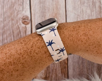 May include: A white and pink patterned watch strap with palm trees and white polka dots. The strap is made of silicone and is compatible with Apple Watch.