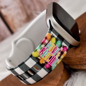 Könnte beinhalten: Ein schwarz-weiß kariertes Apple Watch Armband mit einem bunten "Merry & Bright" Design mit Glühbirnen und einer festlichen Schrift.