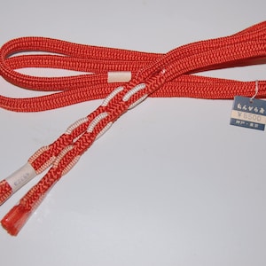 May include: A pair of red and white braided cords with a price tag that reads "¥8500".