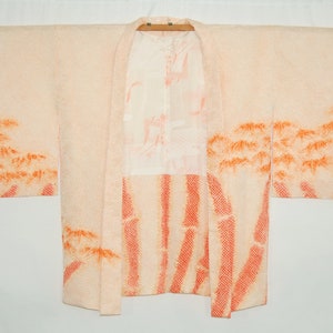 Könnte beinhalten: Ein blassrosa japanischer Kimono mit einem traditionellen orangefarbenen Bambusmuster. Der Kimono hat ein weißes Futter und ist aus einem weichen, leichten Stoff gefertigt.