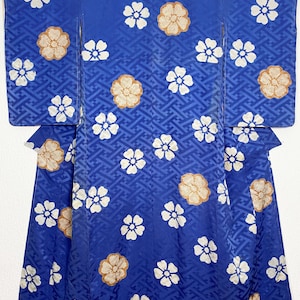 Peut inclure: Un kimono bleu avec un motif floral blanc et or. Le kimono est en soie et présente un design japonais traditionnel.
