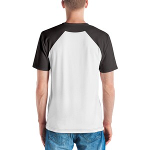 May include: A white and black baseball raglan t-shirt. The shirt has a white front and black sleeves.