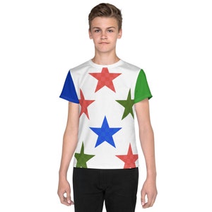 Peut inclure: T-shirt blanc avec un motif d'étoiles colorées. Le motif comprend des étoiles rouges, bleues et vertes sur un fond blanc. Les manches sont bleues et vertes. Le t-shirt est porté par une personne.