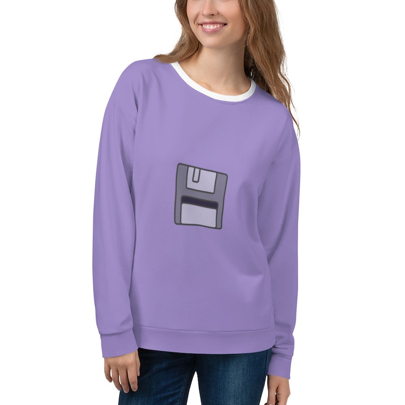 May include: A lavender colored sweatshirt with a white crew neck and a gray floppy disk graphic on the front.