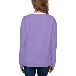 May include: A lavender colored sweatshirt with long sleeves and a crew neck.