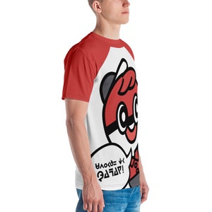 May include: A white and red baseball tee featuring a cartoon character with a red and black design. The character has large eyes and a speech bubble with text. The sleeves are red.