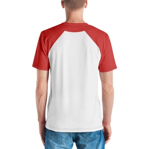 May include: White and red raglan t-shirt. The shirt has a white body with red sleeves and a red crew neck. The back of the shirt is visible, showing the raglan sleeve design. The shirt is made of a soft, comfortable material.