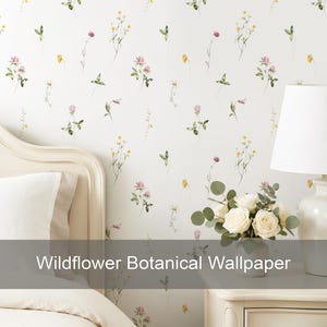 Puede incluir: Papel pintado con fondo blanco y un patrón repetitivo de pequeñas y delicadas flores silvestres en tonos rosa, amarillo y verde. El texto "Wildflower Botanical Wallpaper" está superpuesto en la parte inferior de la imagen.