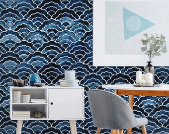 May include: A room interior featuring wallpaper with a repeating dark blue and white wave pattern. A white cabinet with open shelving and a closed door sits against the wall. A wooden table with a gray chair and a glass vase with greenery are present.