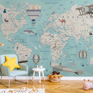 May include: A light blue world map wallpaper featuring illustrations of hot air balloons, airplanes, and animals. A plush giraffe, a light blue armchair with a yellow star pillow, a small white table, and a segmented plush caterpillar are present.