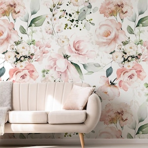 May include: A pale pink sofa with a matching cushion and a grey throw. The backdrop is floral wallpaper featuring large pink and white roses, green leaves, and other flowers.