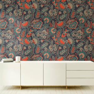 Könnte beinhalten: Ein weißes Sideboard mit zwei Türen und drei Schubladen steht vor einer Wand mit dunkler Tapete, die ein dichtes, sich wiederholendes Muster aus orangefarbenen, blaugrünen und beigen Blumen und Blättern mit komplexen Details zeigt.