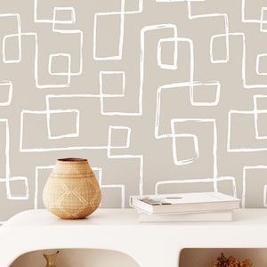 Puede incluir: Un papel pintado de color beige claro con un patrón repetitivo de líneas rectangulares blancas dibujadas a mano. El diseño consiste en formas angulares interconectadas que crean un motivo geométrico continuo en forma de laberinto.