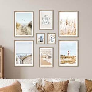 Könnte beinhalten: Eine Sammlung gerahmter Kunstdrucke mit Strandmotiven. Die Drucke zeigen Küstenszenen, darunter ein Holzsteg zum Strand, einen Leuchtturm und Meereswellen. Ein Druck enthält den Text "SEA FEELS LIKE HOME".