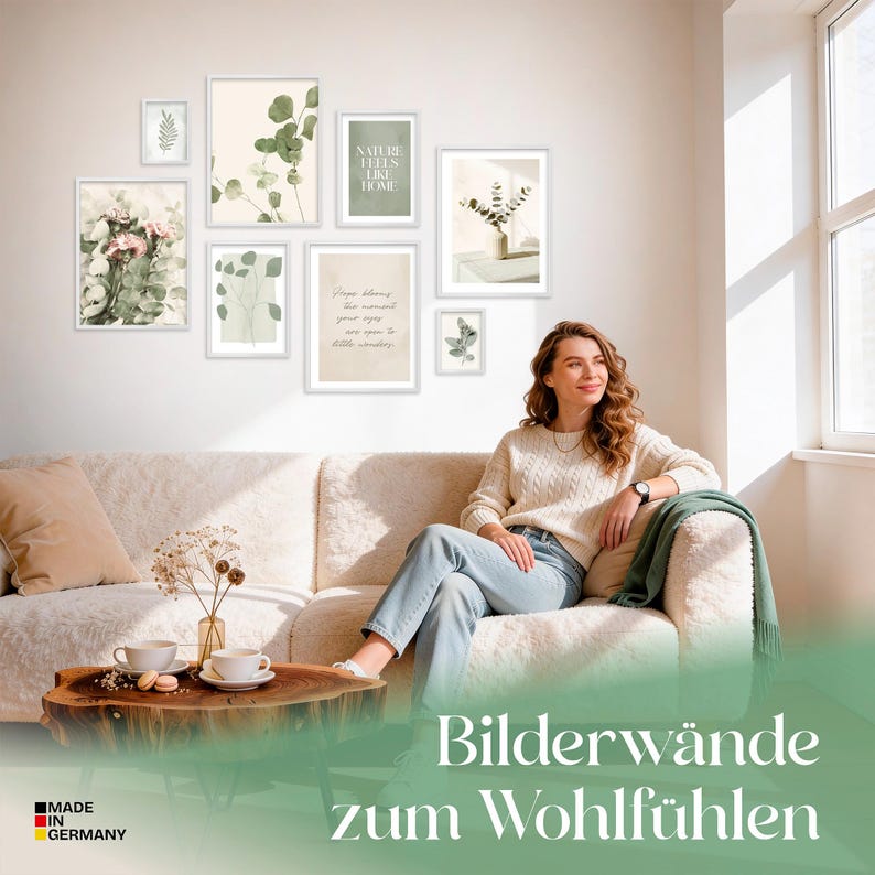 May include: A collection of framed botanical prints in white frames, arranged on a white wall. The prints feature eucalyptus, floral, and inspirational text designs. A woman sits on a cream-colored sofa in front of the wall art.