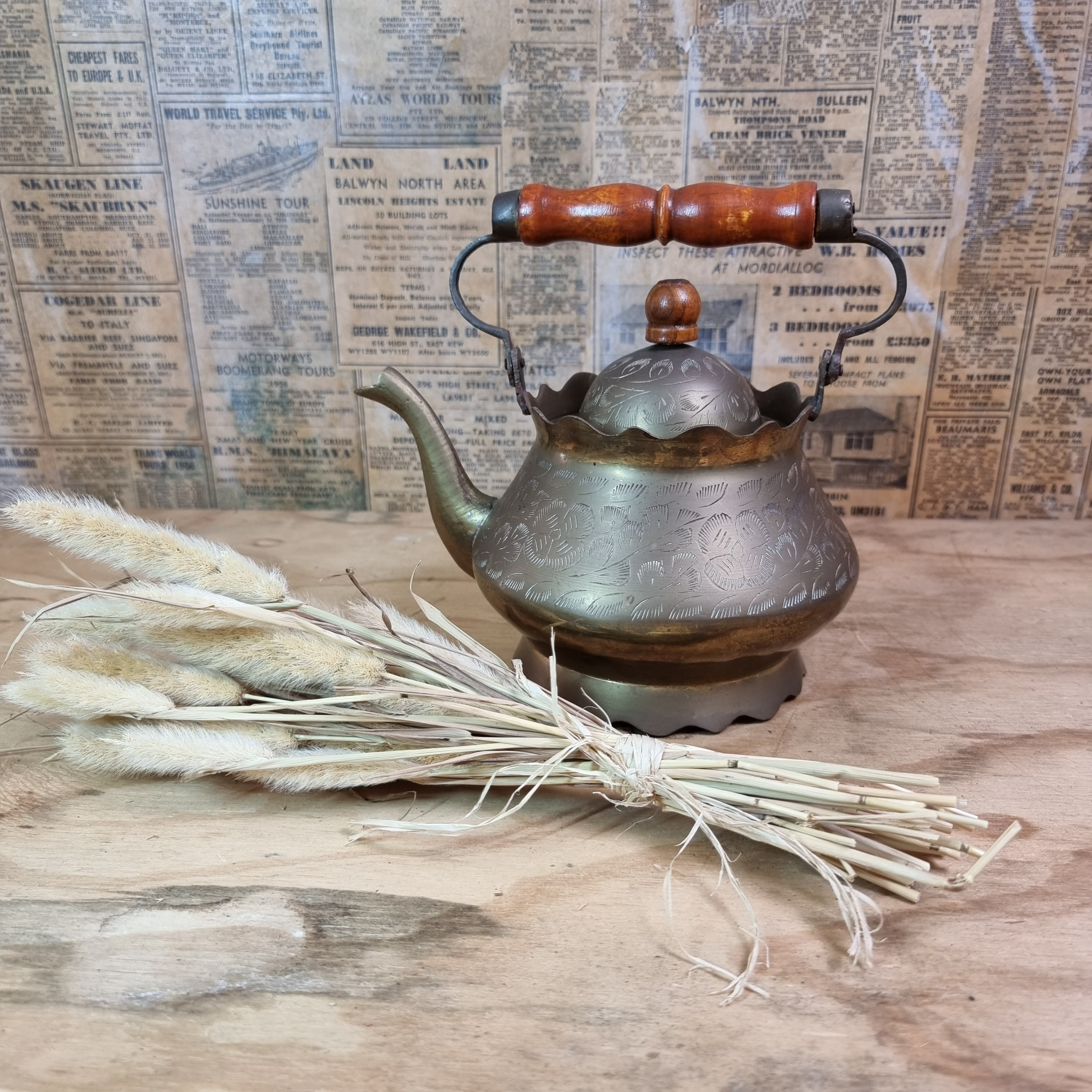 Vintage brass tea kettle with wooden handle.